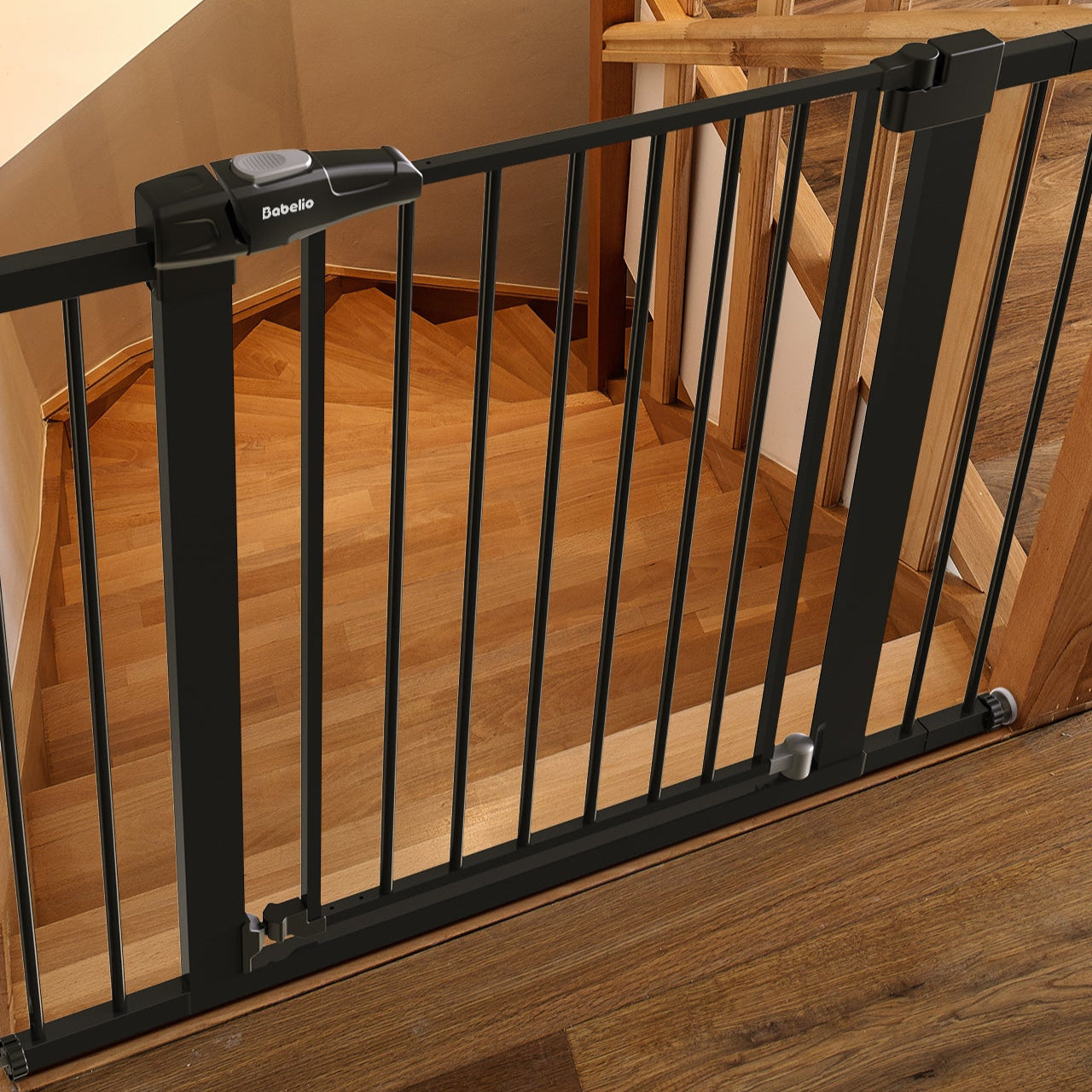 Black metal baby gate installed on a wooden staircase