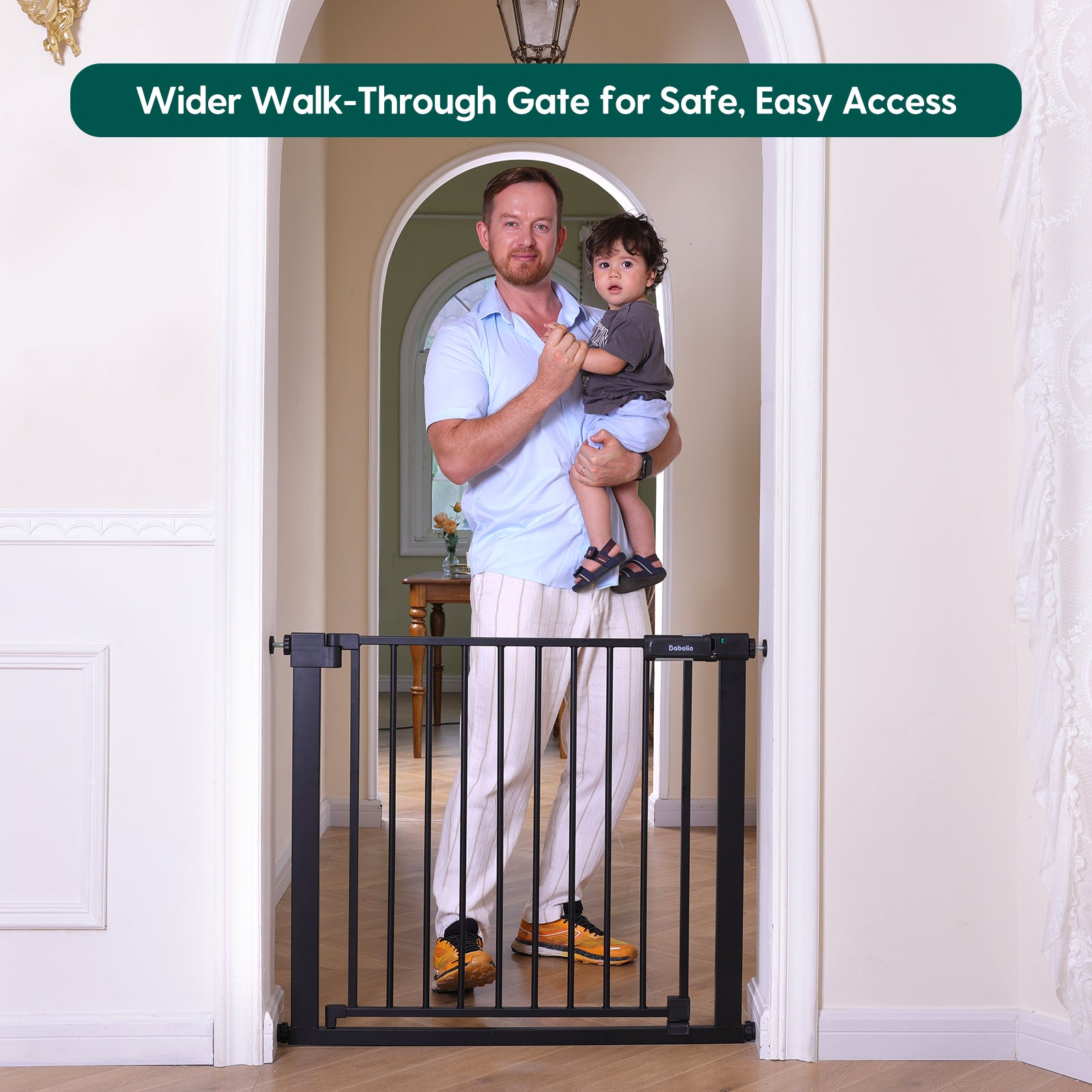 Man holding a child next to a wider walk-through gate in a home setting#Color_Black