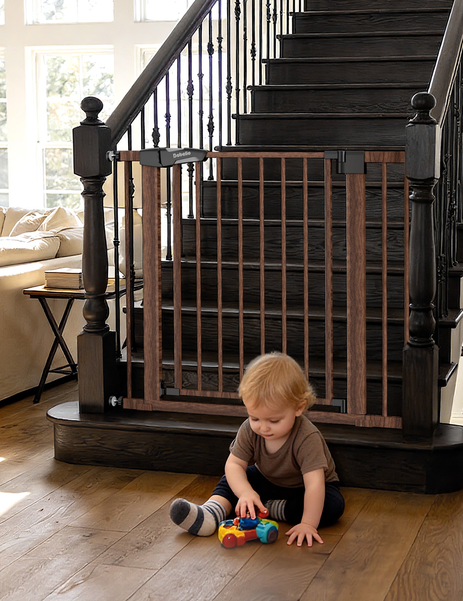 Child playing on a wooden floor with a baby gate in front of a staircase. #Color_Brown Wood Pattern