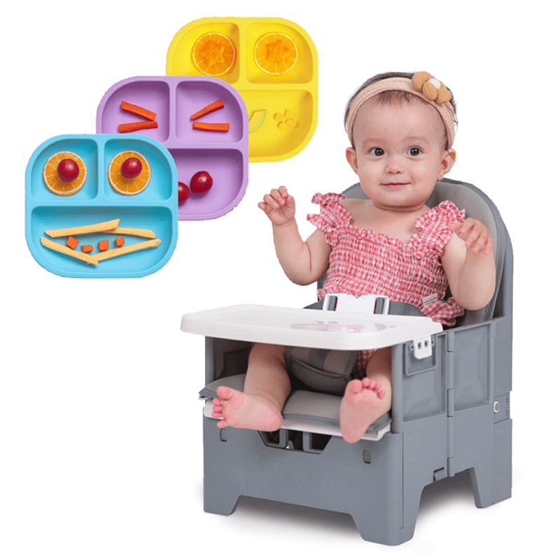 Babelio baby in booster seat with colorful silicone plates and food, kitchen setting