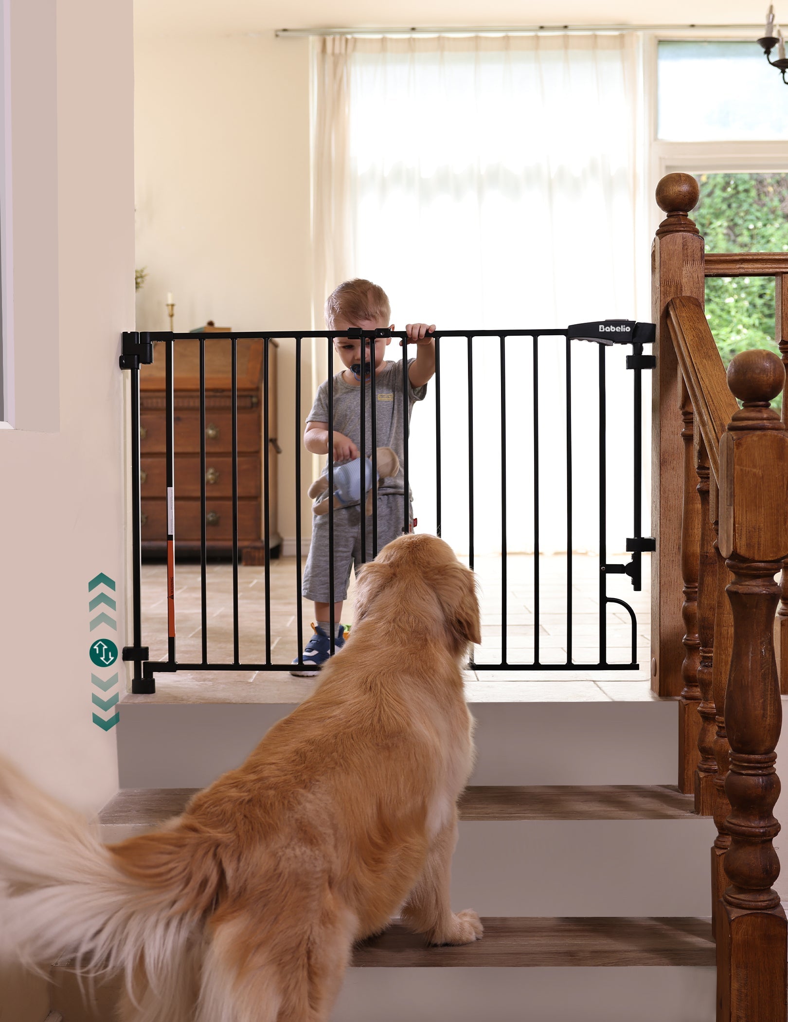 Babelio black baby safety gate on staircase, toddler behind gate, dog in foreground, home setting