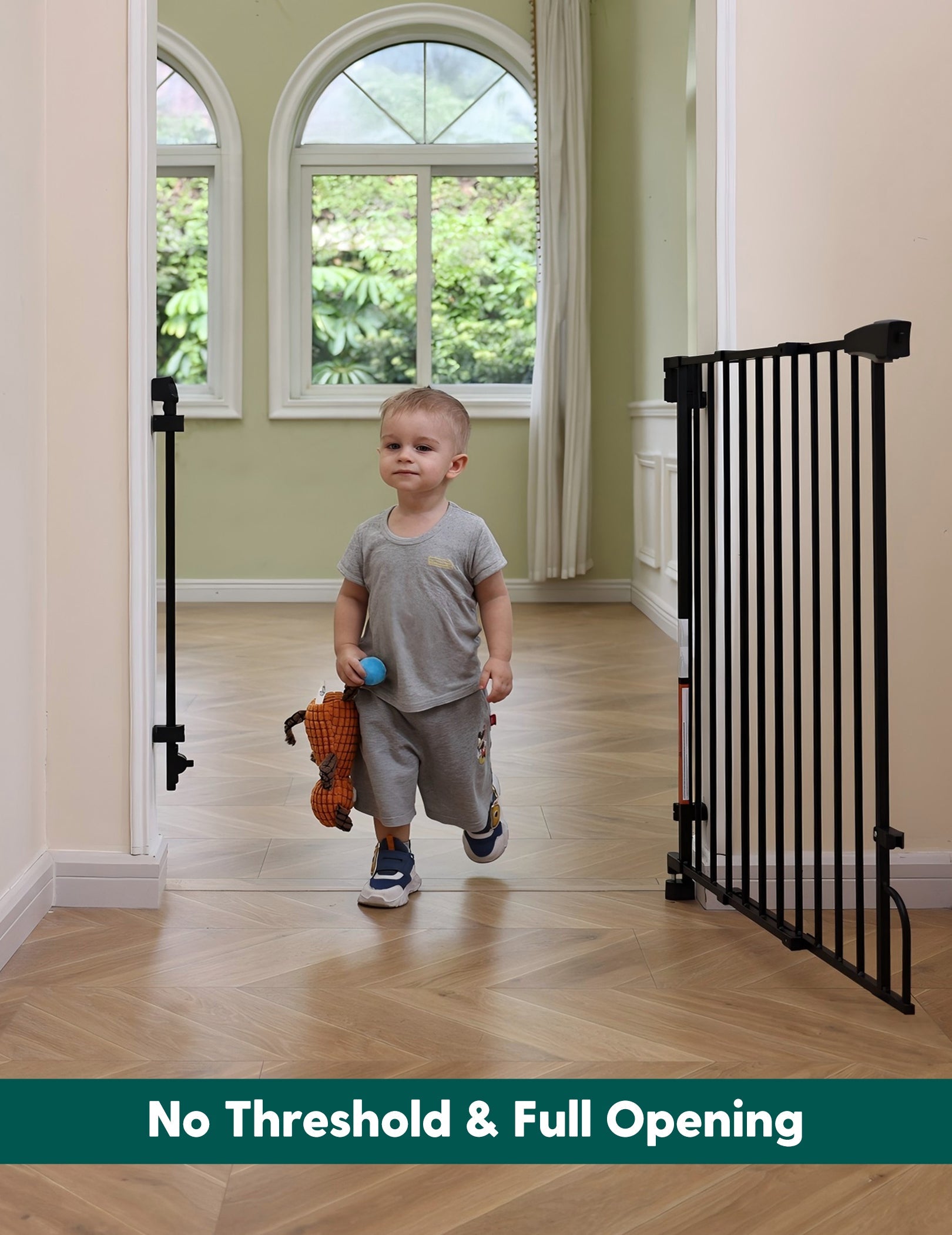 Babelio black baby safety gate installed in a bright hallway, toddler walking through
