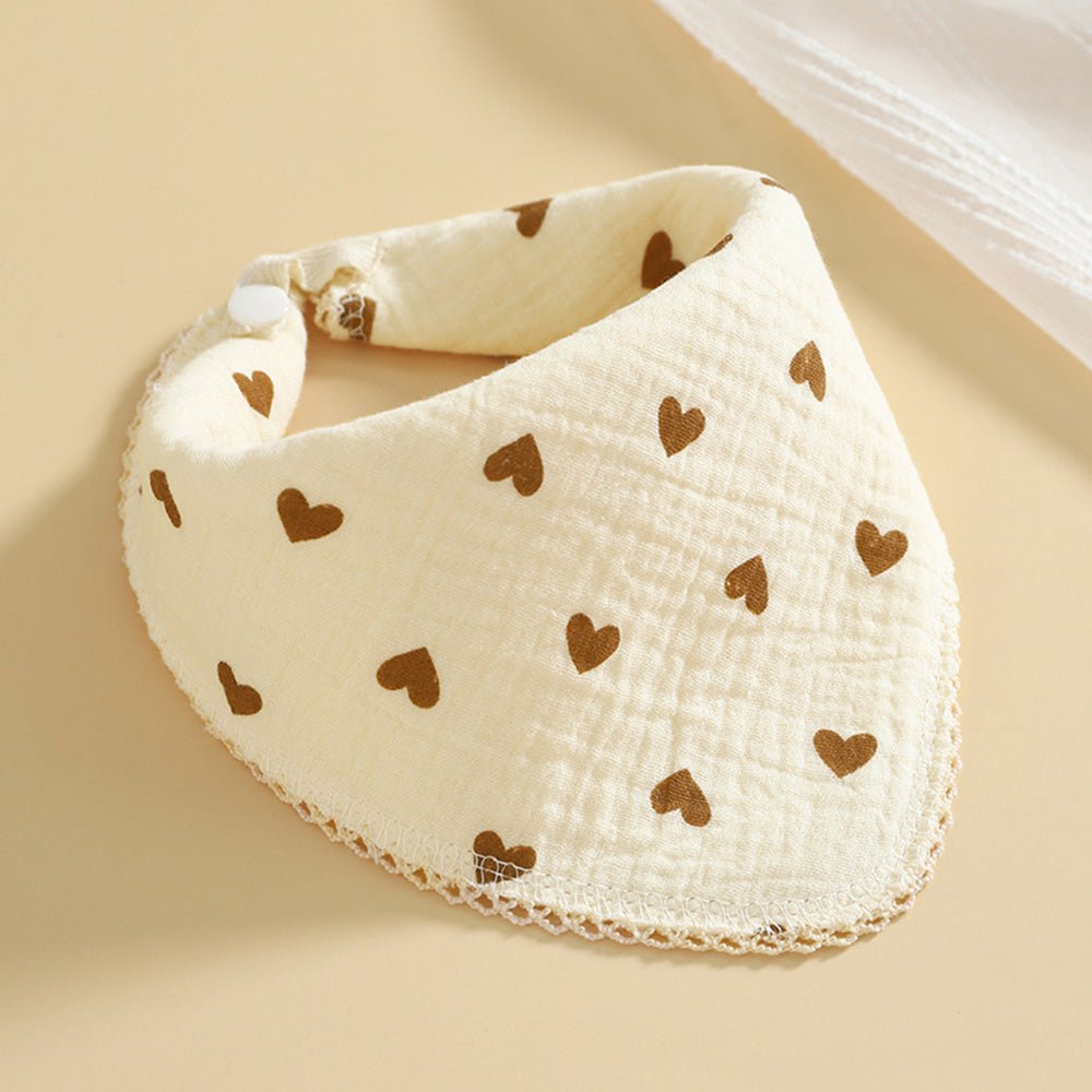 Babelio cotton muslin baby bib with brown heart pattern on a beige background
