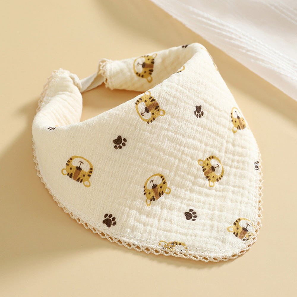 Babelio cotton muslin baby bib with cute animal face and paw print pattern on beige surface
