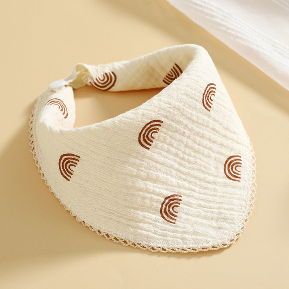 Babelio cream cotton muslin baby bib with brown rainbow patterns on a neutral background