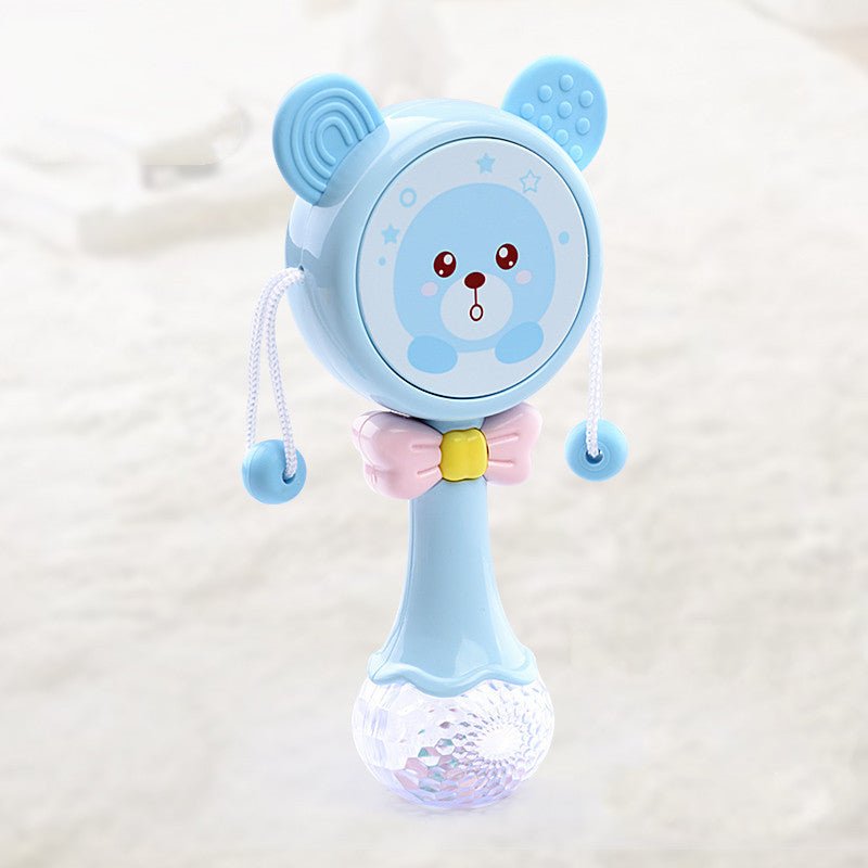 Babelio blue bear baby rattle toy with pink bow in a softly lit nursery setting