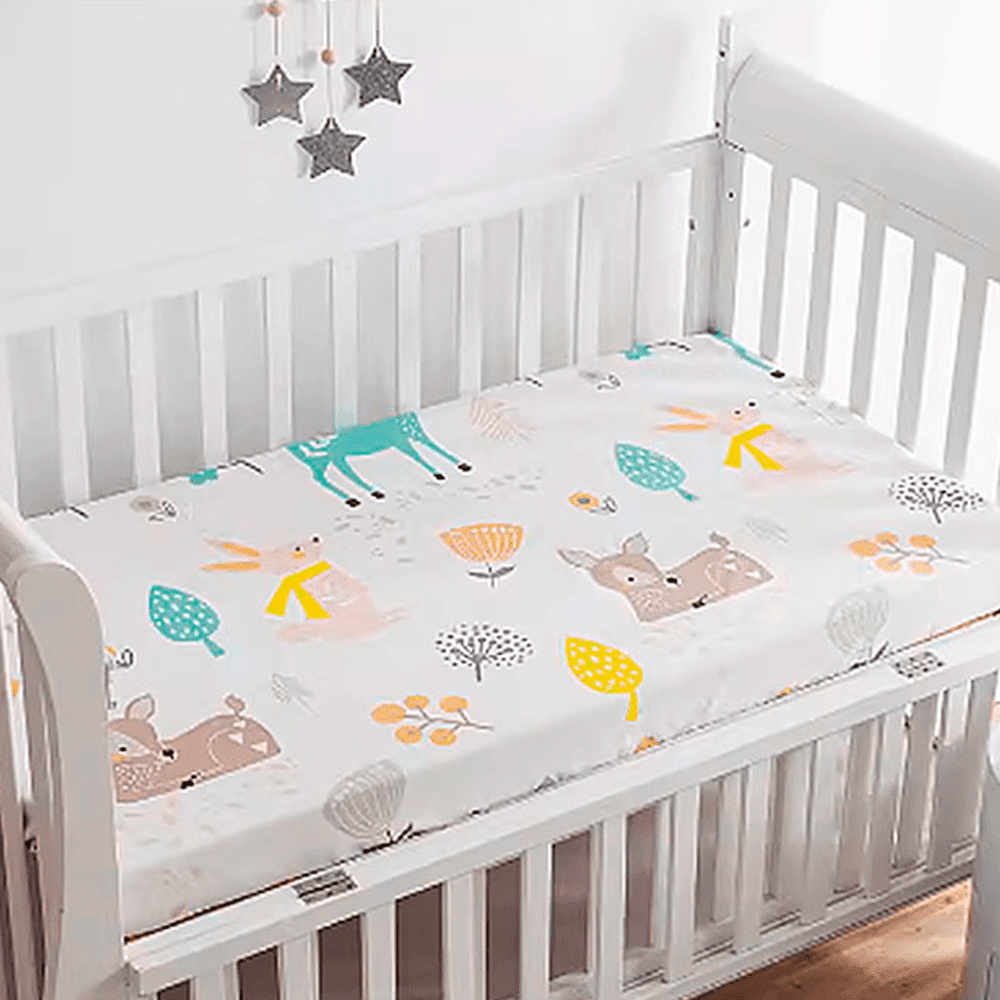 Babelio crib mattress with playful cartoon animals and trees in a white nursery crib