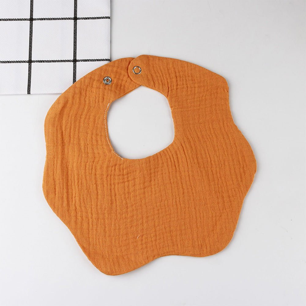Babelio solid orange baby bib with snap closure on white surface
