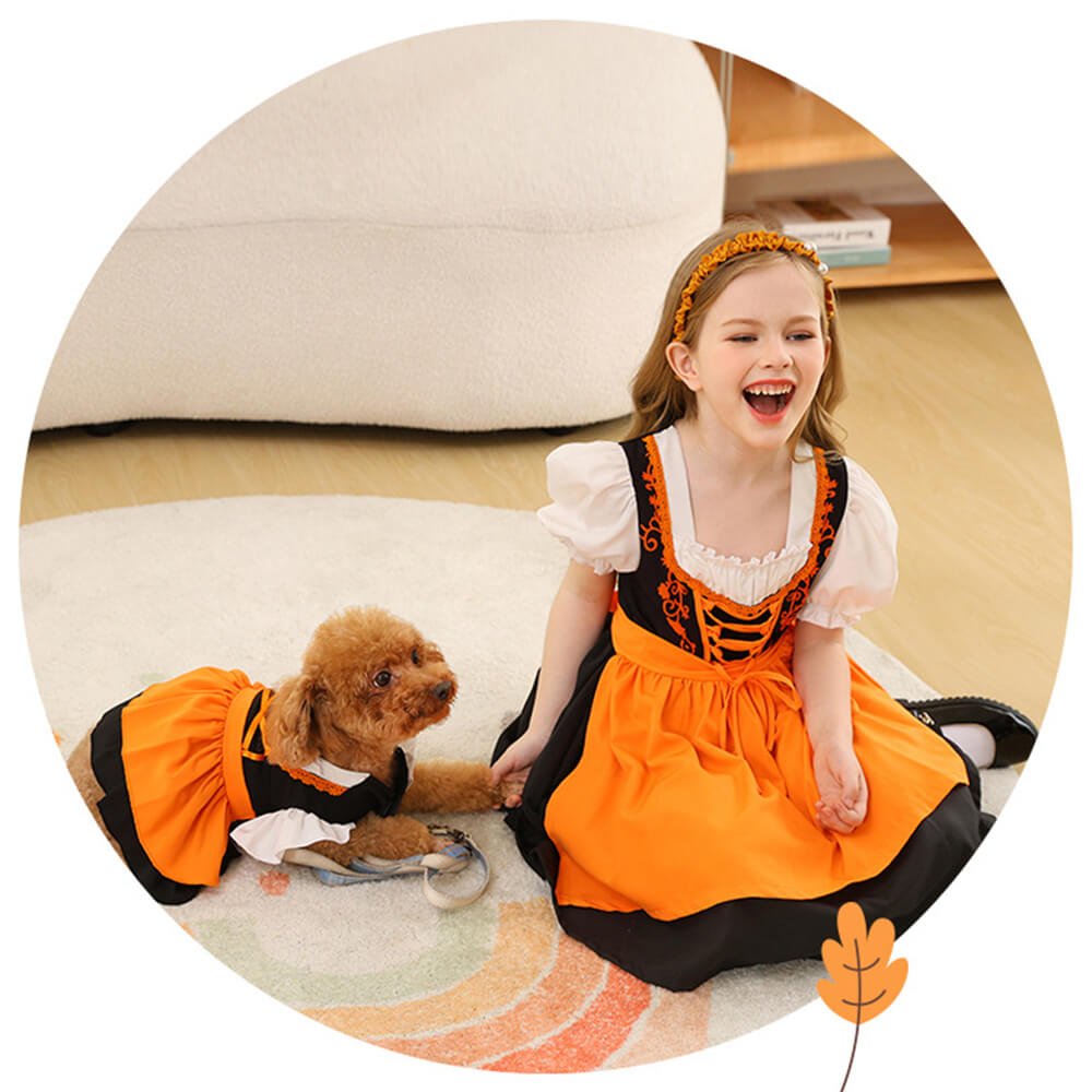 Babelio girl and dog in matching orange and black dresses on a living room rug
