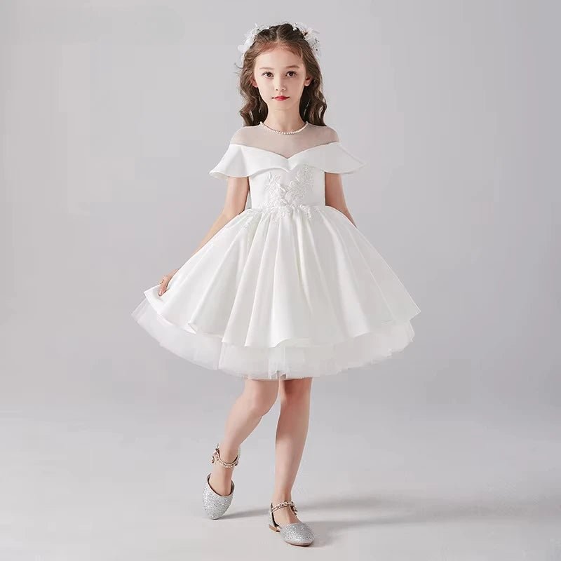 Babelio girl in white formal dress, layered skirt, pearl necklace, plain studio background