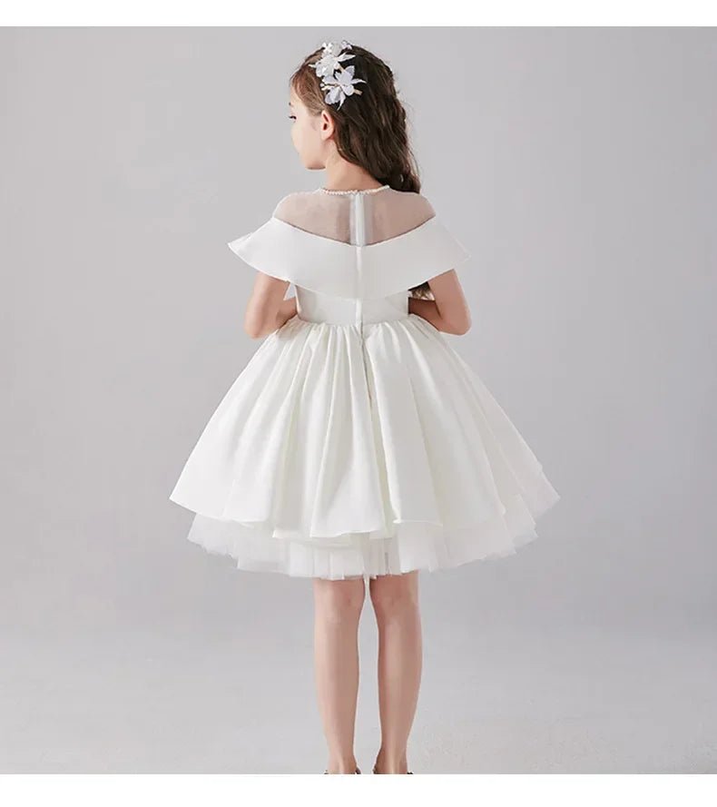 Babelio flower girl wearing a white formal dress in a studio setting
