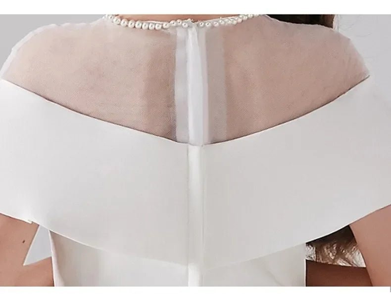 Babelio close-up of white formal flower girl dress with sheer neckline and pearl trim