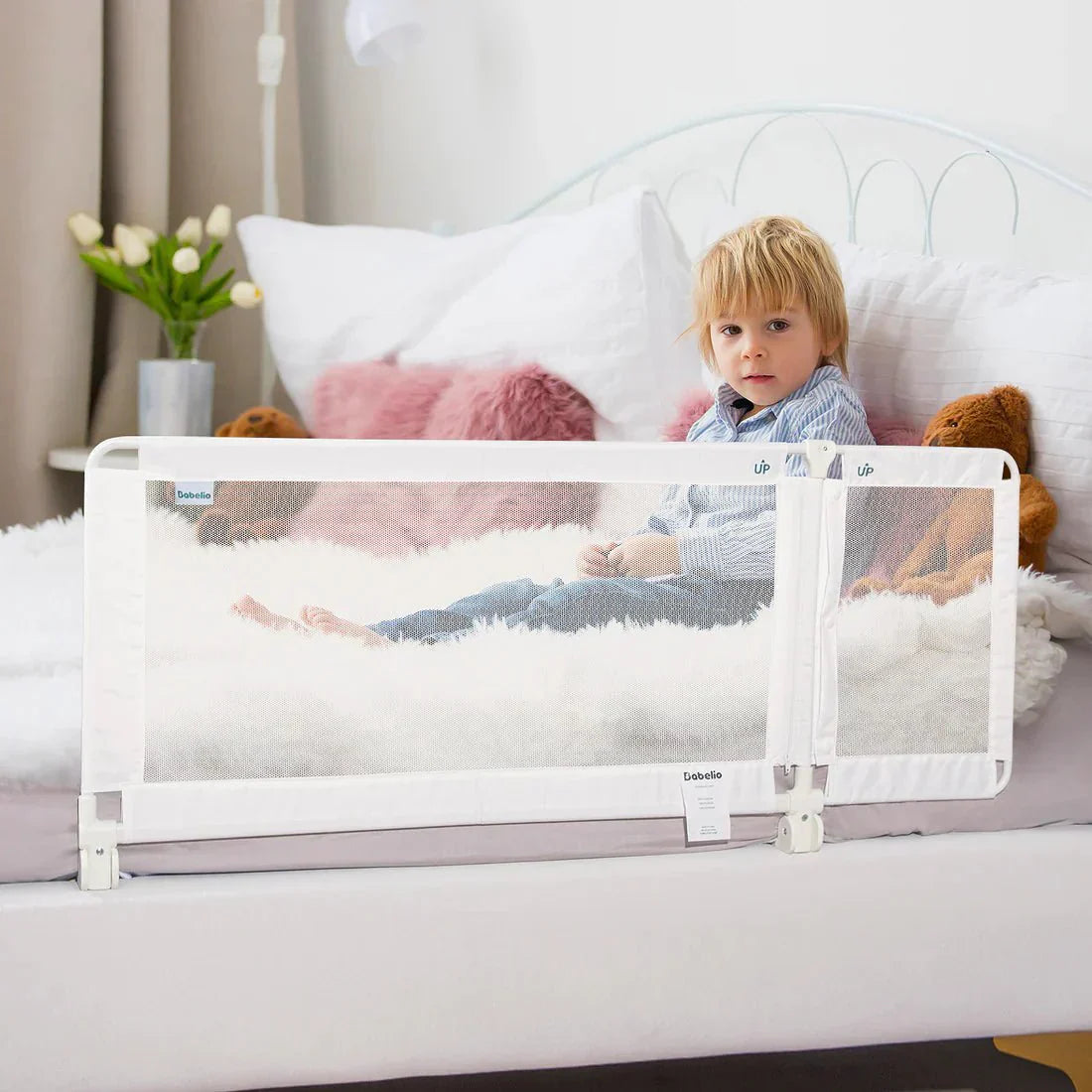 Babelio baby safety gate installed on bed in a cozy bedroom with toddler sitting safely