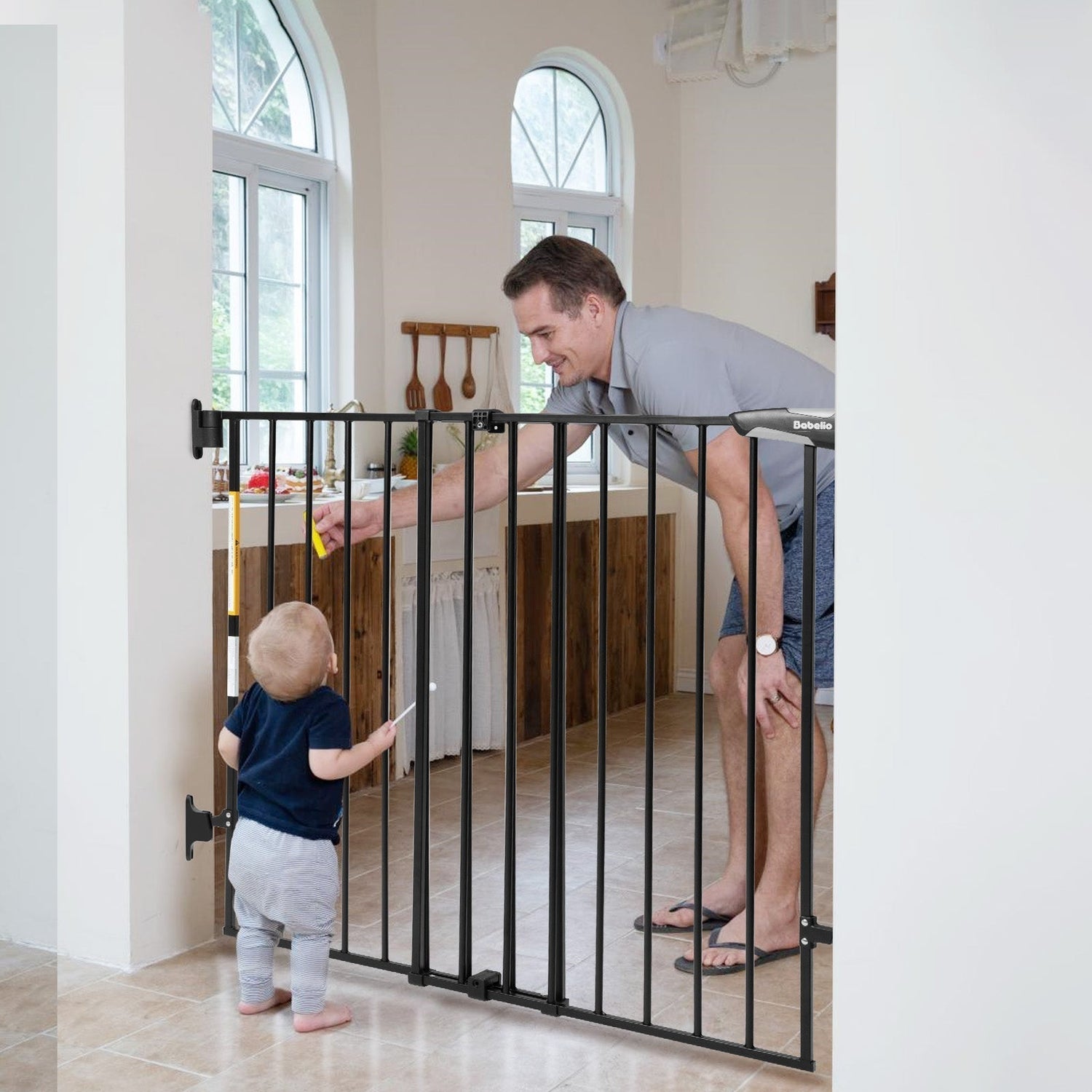 Babelio baby safety gate in kitchen doorway with parent and toddler, modern home setting