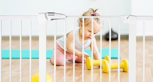 Babelio baby safety gate in a modern playroom with toddler and yellow dumbbells