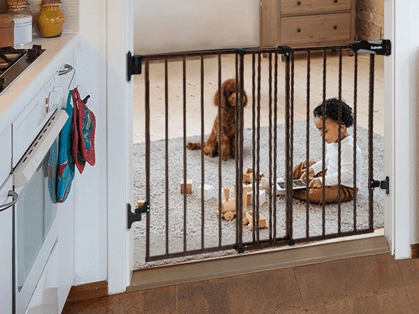 Babelio baby safety gate in doorway with toddler and dog playing on rug in a living room