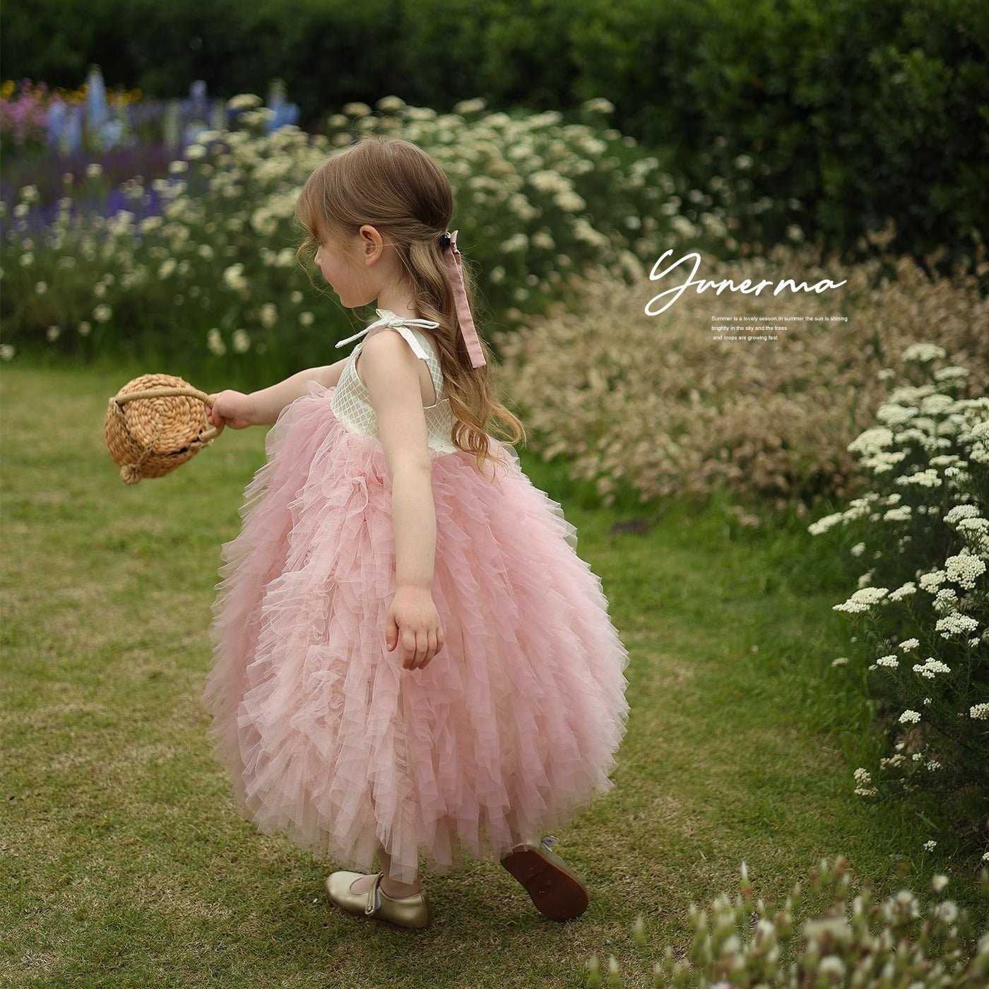 Babelio little girl in pink princess dress holding basket in a garden setting