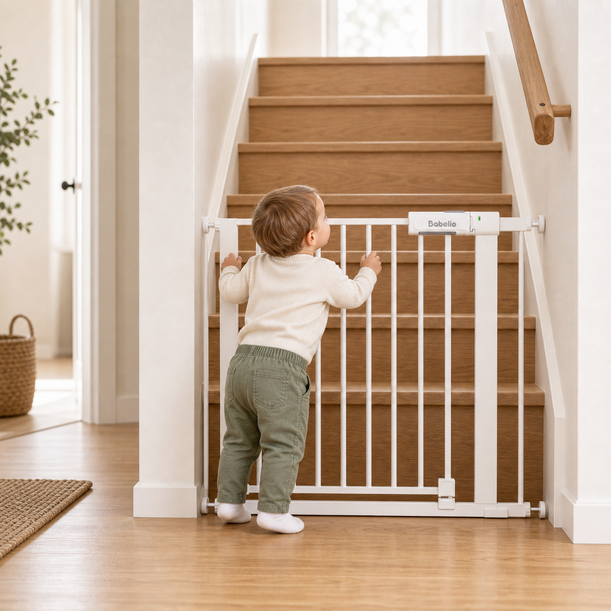 Child standing next to a baby gate at the bottom of a staircase