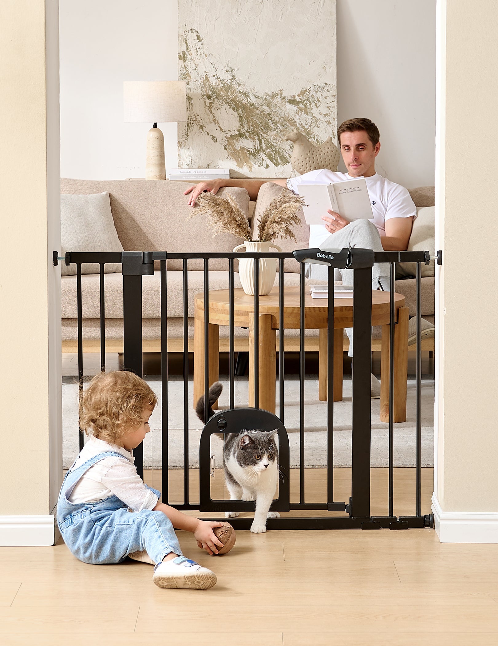 Babelio baby safety gate with cat door in living room, toddler playing, cat passing through