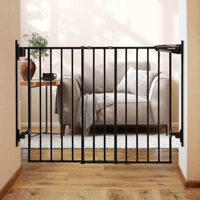 Babelio black baby safety gate installed in living room doorway with sofa and table visible