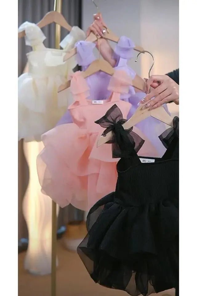 Babelio pastel and black toddler princess dresses on hangers in a well-lit room