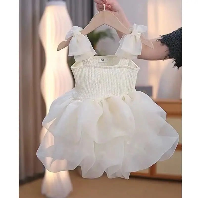 Babelio toddler white fluffy summer dress with tulle ruffles, displayed in a softly lit room.