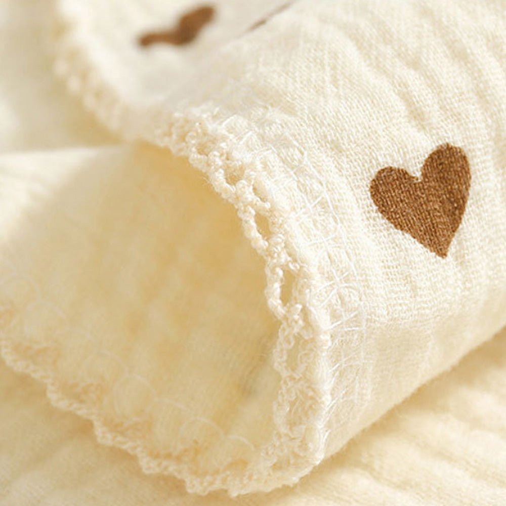 Babelio beige muslin baby bib with brown heart pattern and soft lace trim