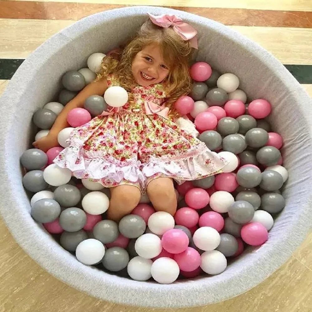 Babelio soft ball pit with pink, white, and gray balls in nursery, child playing inside
