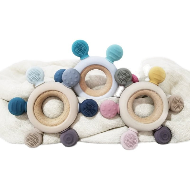 Babelio wooden and silicone baby teething rings on soft fabric, nursery setting