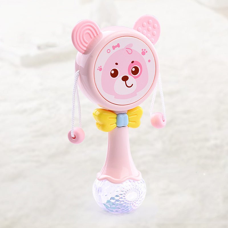 Babelio pink baby rattle toy with bear face and yellow bow on a soft nursery surface