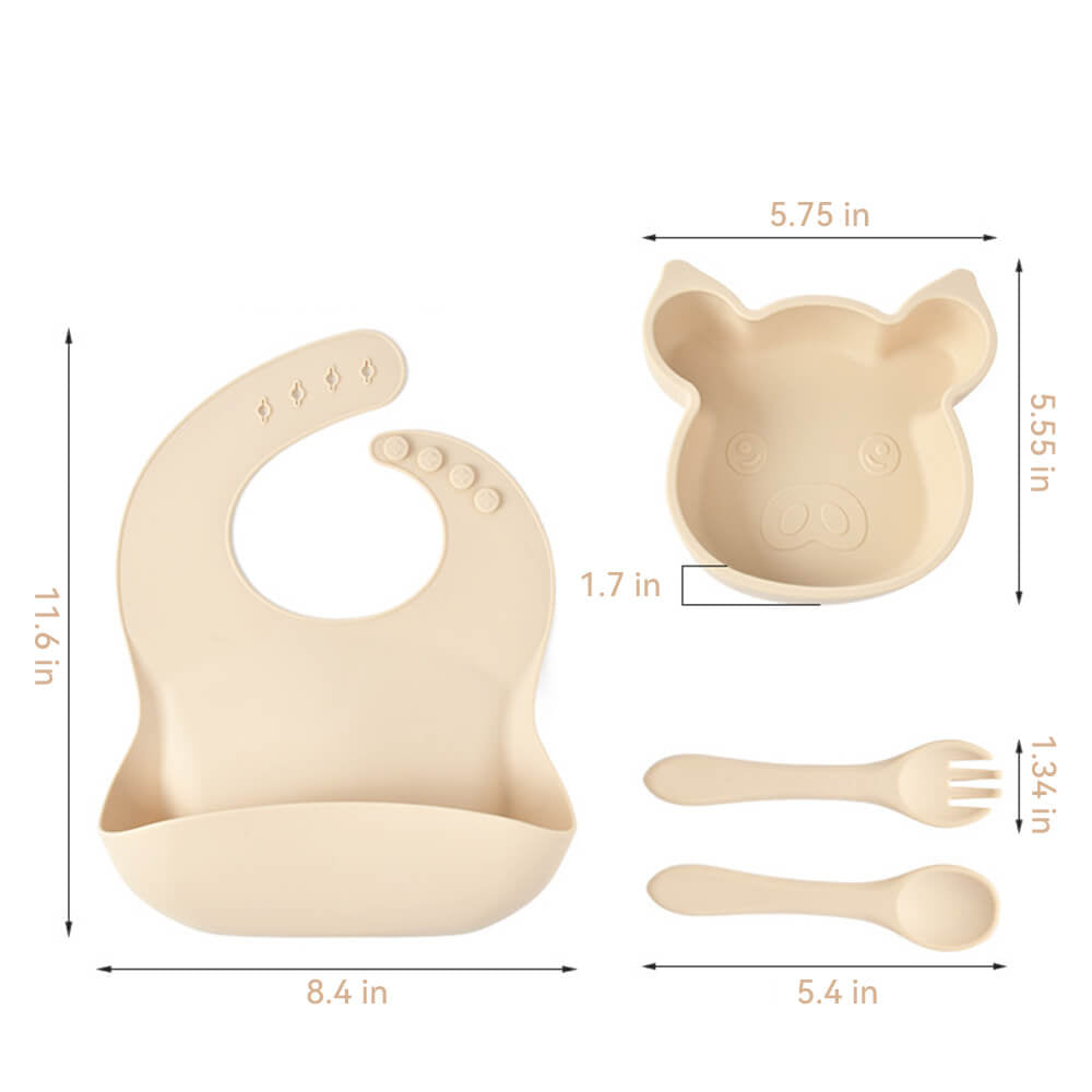 Babelio beige silicone piggy baby dinnerware set with bib, plate, fork, and spoon on white background