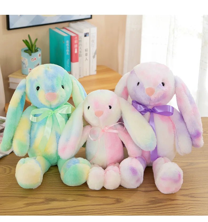 Babelio pastel plush bunny toys with bows on a nursery desk, colorful and soft decor