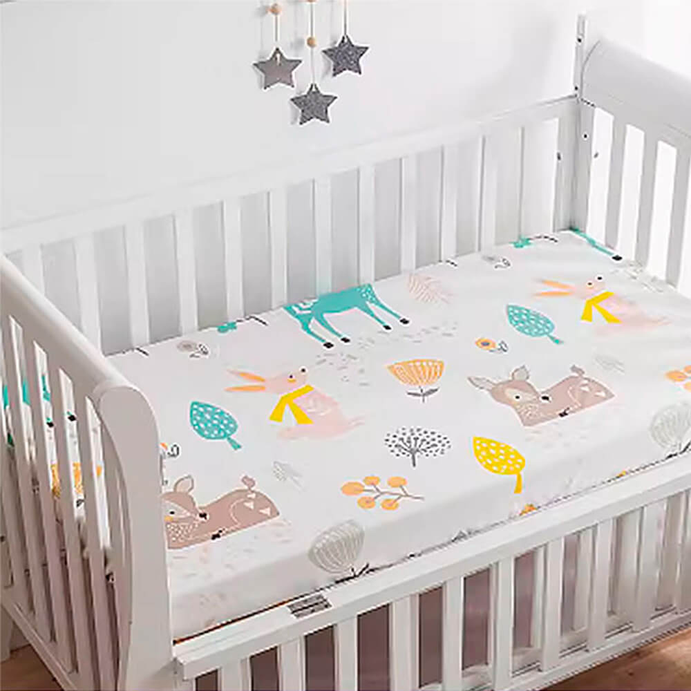 Babelio crib mattress with playful cartoon animal fitted sheet in a bright nursery