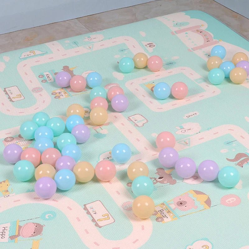 Babelio pastel play balls on a colorful baby play mat in a nursery setting