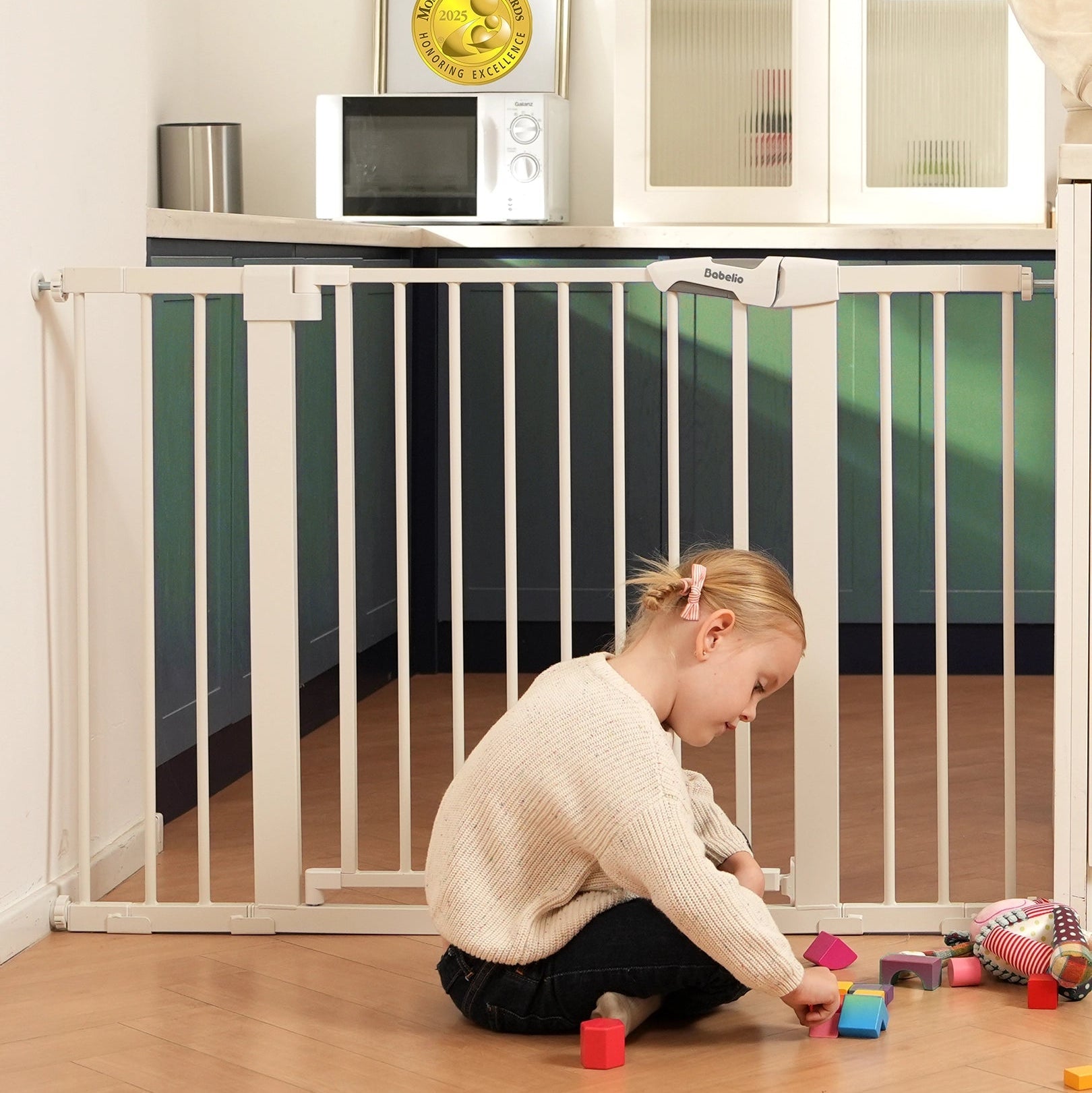 Babelio baby safety gate installed in a kitchen with a child playing on the floor