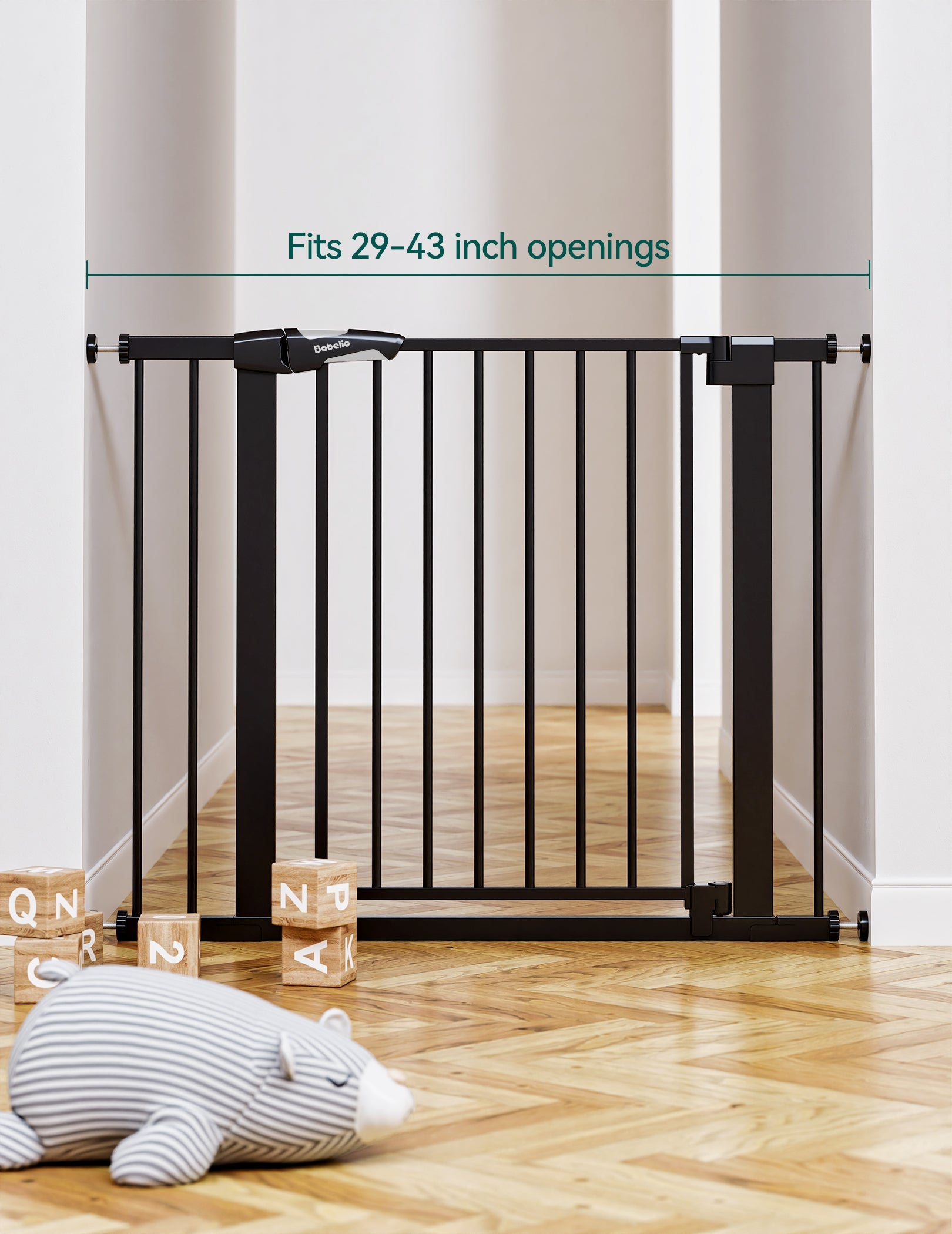 Babelio baby safety gate installed in a modern hallway with toys and wooden blocks on floor.