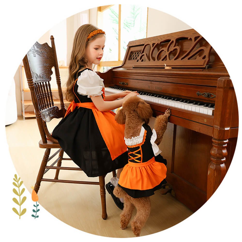 Babelio girl in orange dress and dog in matching costume at piano in living room