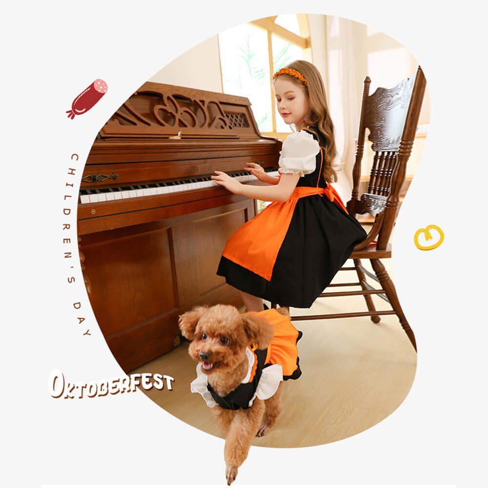 Babelio girl in orange and black dress at piano, matching dog outfit, living room setting.
