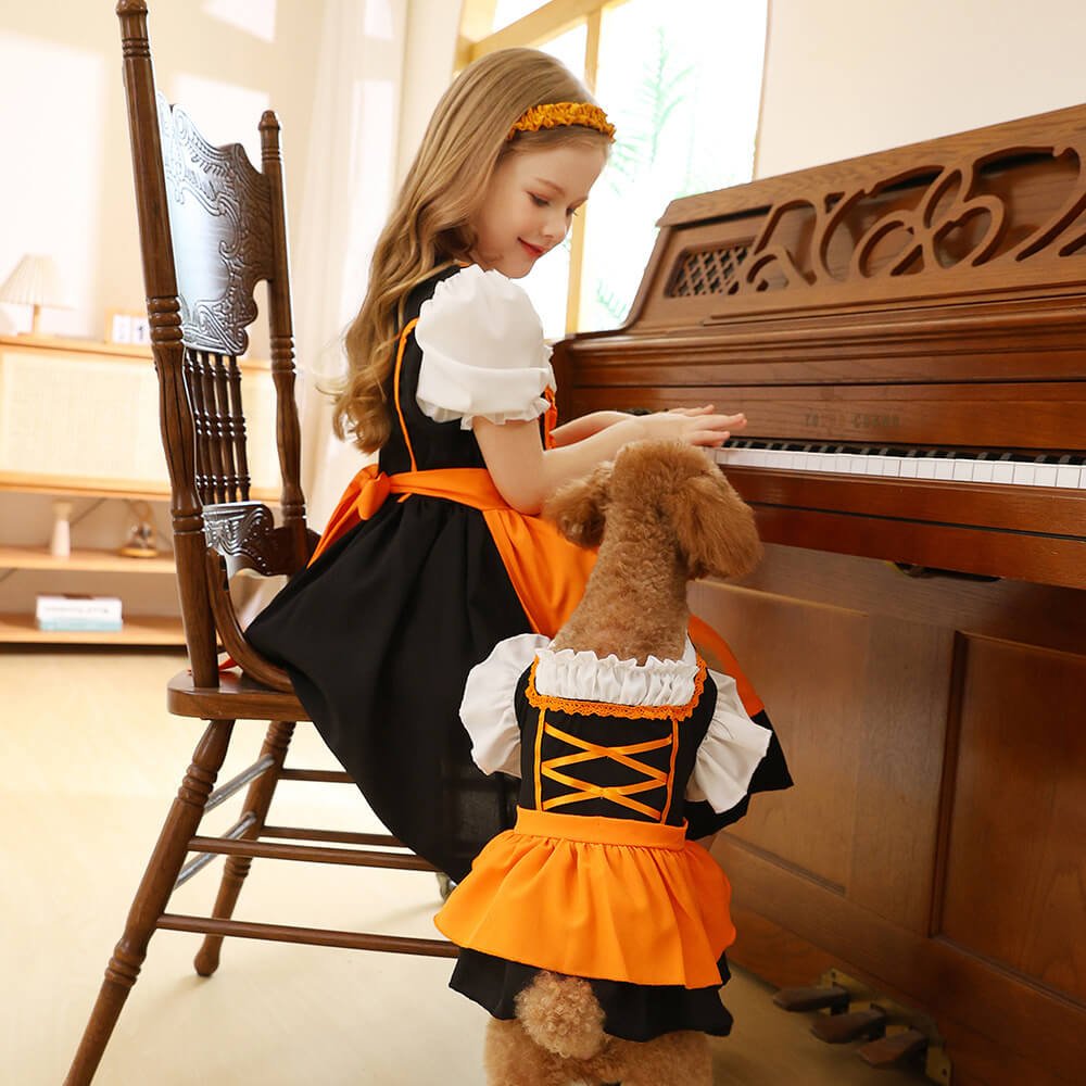 Babelio girl in orange dress with dog in matching outfit playing piano in living room