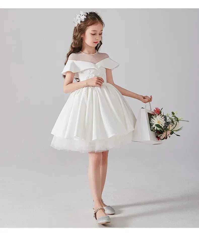 Babelio girl in elegant white dress holding flowers, formal photo in studio setting