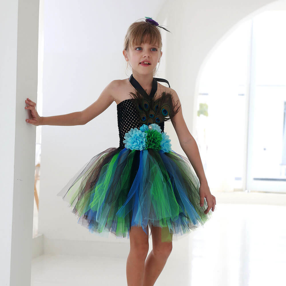 Girl in colorful peacock tutu dress by Babelio, standing in bright indoor space