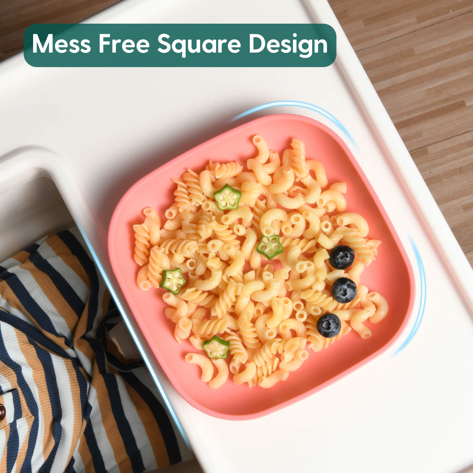 Babelio pink silicone toddler plate with pasta and fruit on a high chair in kitchen setting